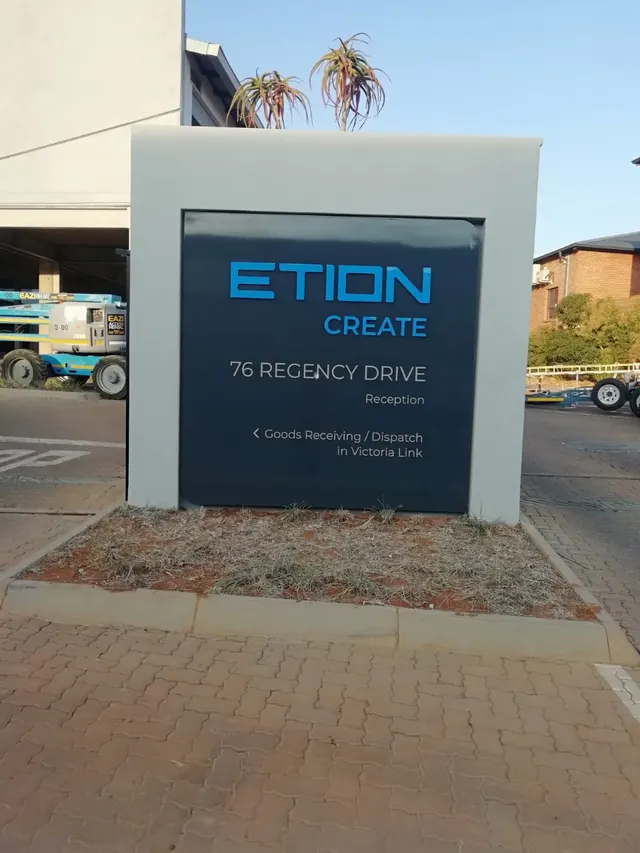 Etion branded entrance pylon beside the approach to the building