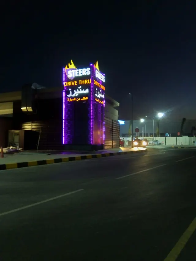 Steers Oman illuminated pylon at night