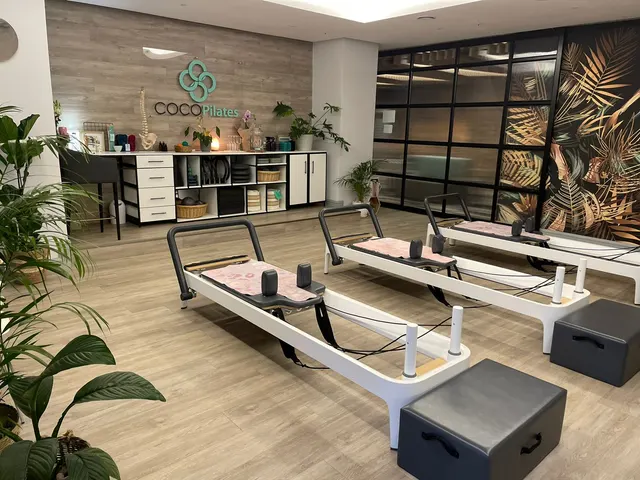 Coco Pilates studio interior with dimensional wall lettering and reformer equipment